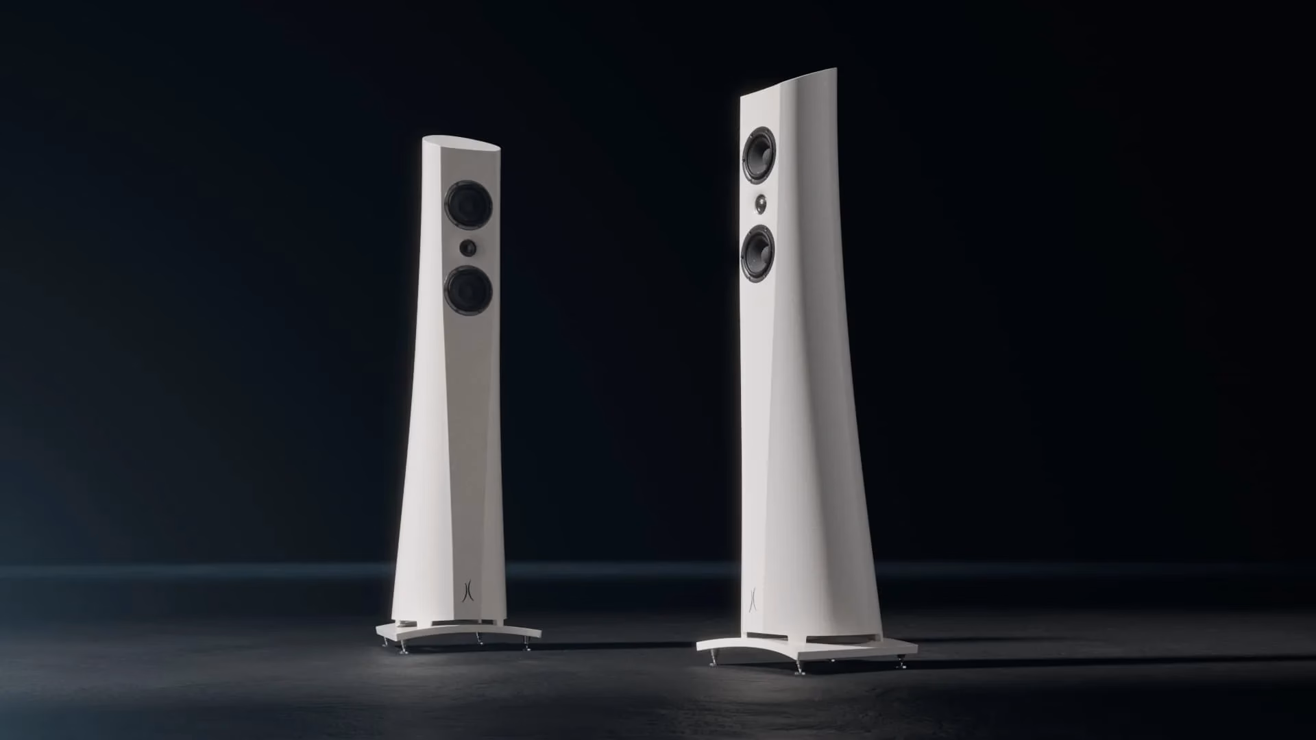 Two tall speaker systems on a dark background